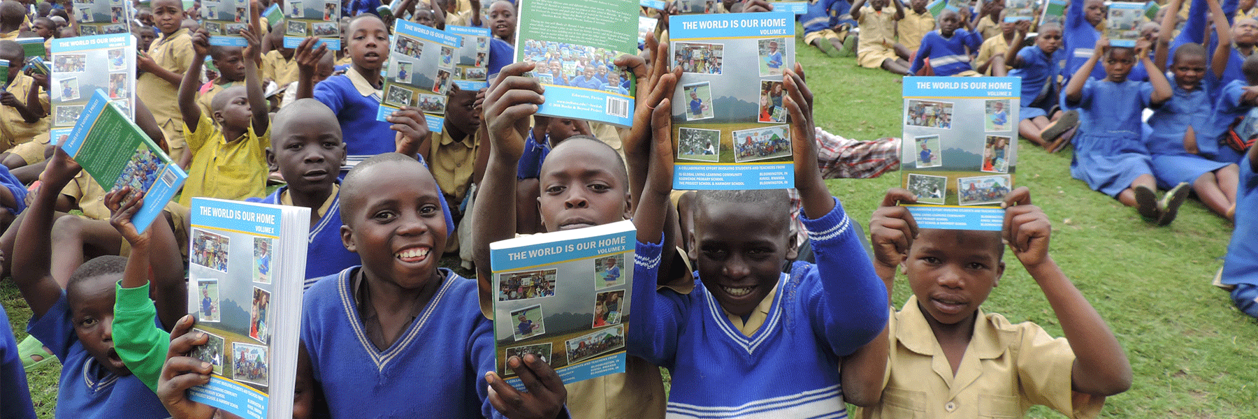 Children in school uniforms hold up issues of The World is Our Home in the air